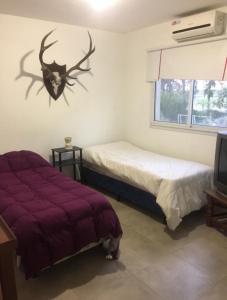 ein Schlafzimmer mit 2 Betten und einem Hirschkopf an der Wand in der Unterkunft Barrio cerrado premium in Dique Luján
