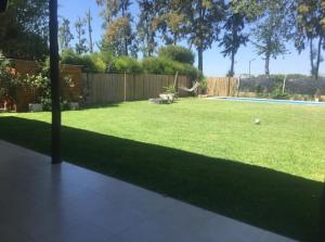 ein Hof mit einem Rasenhof mit einem Pool in der Unterkunft Barrio cerrado premium in Dique Luján