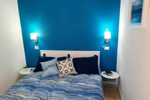 um quarto azul com uma cama com almofadas em Meli's House em Vibo Valentia