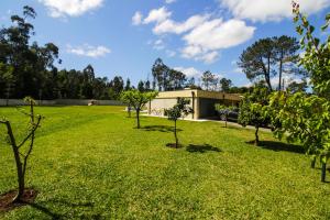 a garden with trees in front of a building at River house in Vila Nova Cerveira in Vila Nova de Cerveira