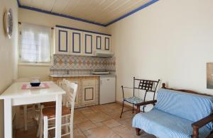a kitchen with a table and a table and chairs at Chiliadromia Studios in Alonnisos
