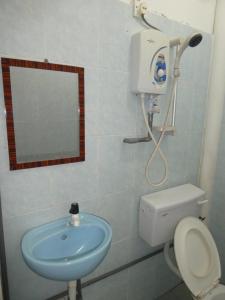 a bathroom with a sink and a toilet and a mirror at TIT MOTEL in Sungai Petani