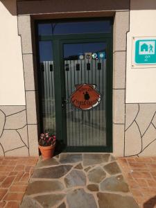 Una puerta verde con un cartel. en Albergue Pension Porta Santa, en Baleira
