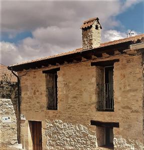 an old stone building with a chimney on top of it at FUENTETRIGO II in Brizuela