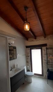 a bathroom with a toilet and a sink and a window at FUENTETRIGO II in Brizuela