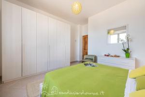 a bedroom with a green bed and white cabinets at Casa Acqua Dolce in Cala Gonone +9 photos