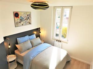 1 dormitorio con cama y ventana en Le Renommé Soissons par Picardie Homes, en Soissons