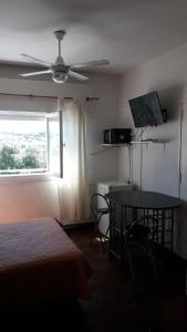 1 dormitorio con cama, mesa y ventana en CARLOS PAZ, Dpto, 3 Huésped en Villa Carlos Paz