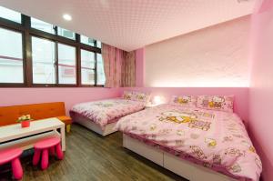 羅東鎮的住宿－遇見小太陽，配有粉红色墙壁和窗户的客房内的两张床
