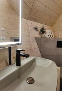 Chalet Velika Planina-I FEEL ALPS في Stahovica: حمام مع حوض أبيض ومغسلة