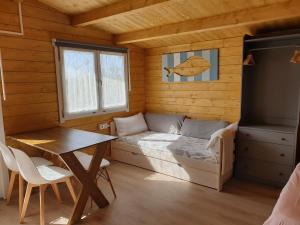 a bedroom with a bed and a table in a cabin at RinloCosta Camping in Rinlo