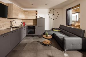 sala de estar con sofá y cocina en Sweet Dolomiti Sonneck, en Maranza
