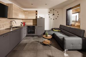 a living room with a couch and a kitchen at Sweet Dolomiti Sonneck in Maranza
