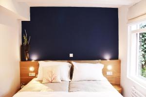 a bedroom with a blue wall and a bed with pillows at Blueprint B&B - Breakfast & Bikes in Amsterdam