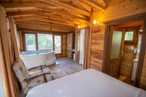 a bedroom with a tub and a bed in a cabin at Sea Valley Lodge in Faralya