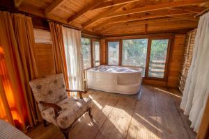 a bathroom with a tub in a room with windows at Sea Valley Lodge in Faralya