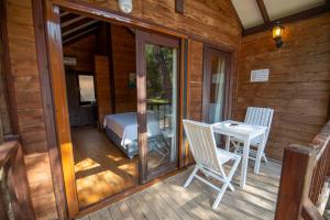 a porch of a cabin with a bed and a table at Sea Valley Lodge in Faralya