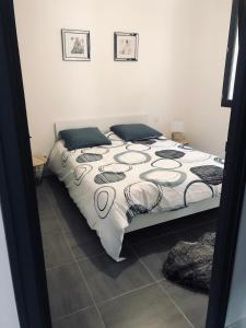 キュキュニャンにあるGîte l’olivierのベッドルーム1室(大型ベッド1台、白い掛け布団付)