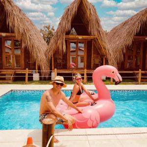 dos personas sentadas en un flamenco rosa en una piscina en Palomino Sunrise en Palomino
