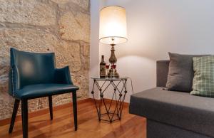 a living room with a chair and a table with a lamp at Authentic Porto Apartments in Porto