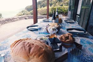 a table with a loaf of bread and bottles of wine at Baía de Canas Villa in São Roque do Pico +44 photos