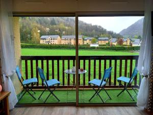 a balcony with chairs and a table with a view at Appartement Cabine St-Lary-Soulan, Calme, Entièrement Rénové in Saint-Lary-Soulan