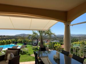 un patio avec une table et des chaises et une piscine dans l'établissement Casa Das Palmeiras, à Loulé