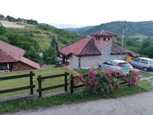 a wooden fence in front of a house with flowers at Apartman Gradac Deguric in Valjevo
