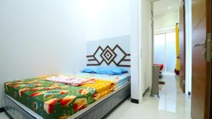 a bedroom with a bed with a colorful blanket at Villa Harmoni Syariah by Masterpiece Villa in Karangploso +5 photos