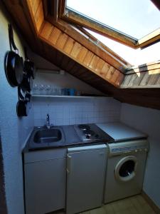 a kitchen with a sink and a washing machine at Studio La Belle Vie in Suresnes