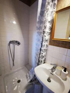 a bathroom with a sink and a tub and a shower curtain at Studio La Belle Vie in Suresnes