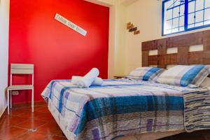 Un dormitorio con una cama con una pared roja. en Villa Stahl, en San Salvador