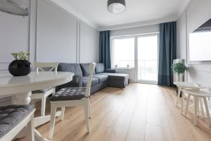 a living room with a couch and a table at Baltic Apartments Seaside Residence in Gdańsk
