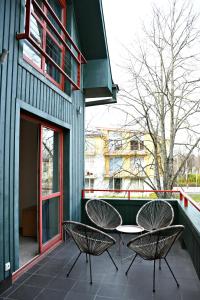 eine Terrasse mit zwei Stühlen und einem Tisch an einem Gebäude in der Unterkunft Žalias namas in Palanga