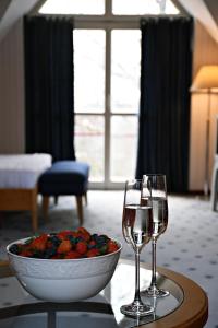 a table with two wine glasses and a bowl of fruit at Žalias namas in Palanga