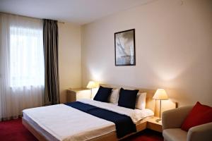 ein Hotelzimmer mit einem Bett und einem Fenster in der Unterkunft Žalias namas in Palanga