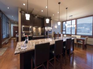 a kitchen with a large island with bar chairs at 901 by Fernie Central Reservations in Fernie