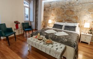 a bedroom with a large bed with a stone wall at Authentic Porto Apartments in Porto