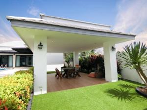 a patio with a table and a lawn at Lux9 Private Pool Villa HuaHin in Hua Hin