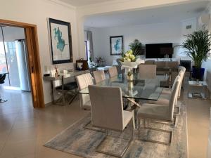 une salle à manger avec une table et des chaises en verre dans l'établissement Casa Das Palmeiras, à Loulé