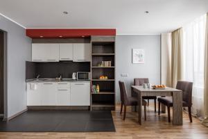 a kitchen and dining room with a table and chairs at Vertical Aparthotel in Saint Petersburg