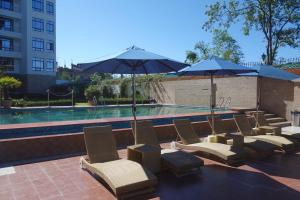 - un groupe de chaises longues et de parasols à côté de la piscine dans l'établissement Sobralia Casino Resort & Spa, à Namchi