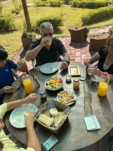 Eine Gruppe von Menschen, die an einem Tisch sitzen und Essen essen. in der Unterkunft Finca La Penúltima-Posada in San Rafael