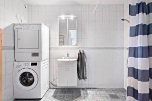 een badkamer met een wasmachine en een wastafel bij Björkö, lägenhet nära bad och Göteborg in Göteborg