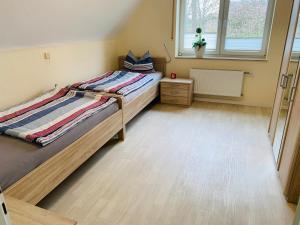 a small bedroom with two beds and a window at Schrapper in Grönheim