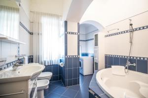 a bathroom with three sinks and a tub and toilets at Apartment Villa Regaly in Opatija