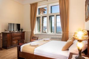 a bedroom with a bed and a large window at Apartment Villa Regaly in Opatija