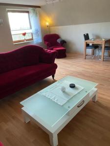 ein Wohnzimmer mit einem roten Sofa und einem Couchtisch in der Unterkunft Hof Beuck in Travenhorst