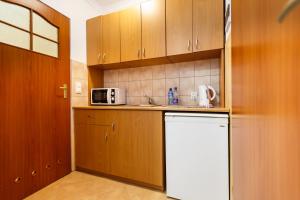a kitchen with wooden cabinets and a white refrigerator at Mała Wenecja - pokoje gościnne in Nowe Worowo