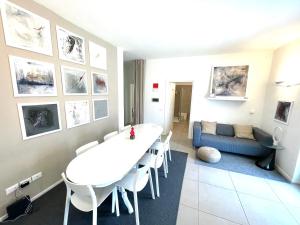 a living room with a white table and a blue couch at Carly's Rooms in Nago-Torbole